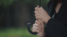 Close up,Businesswoman holding an umbrella in the rain,Slow motion