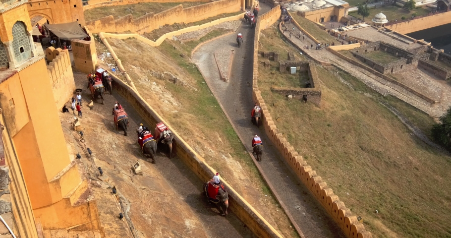Tourists riding elephants on ascend to Amer (Amber) fort, Rajasthan, India. Amer fort is famous tourist destination and landmark