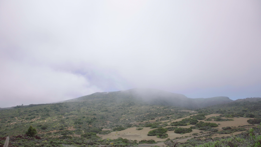 Timelapse of a hill with bushes and various vegetation, ikhmars that quickly pass over the mountain