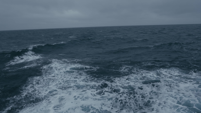 Storm at sea. Waves from ship. Wind breaks waves. White foam on wind. Side view along ship. Splashes. Royalty-Free Stock Footage #1096491069