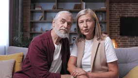 Mature happy couple communicates online call. A gray-haired husband and wife are talking to relatives on the phone. Video call on smartphone. Remote communication.
