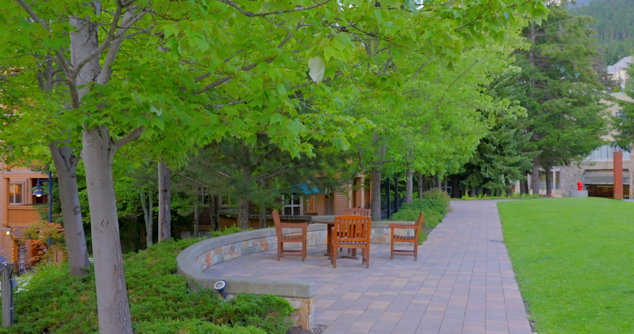 Establishing shot of nice outdoor landscape with table, chairs and green background in Vancouver, Canada, North America. Sunny. Day time on June 2022. Still camera view. ProRes 422 HQ.