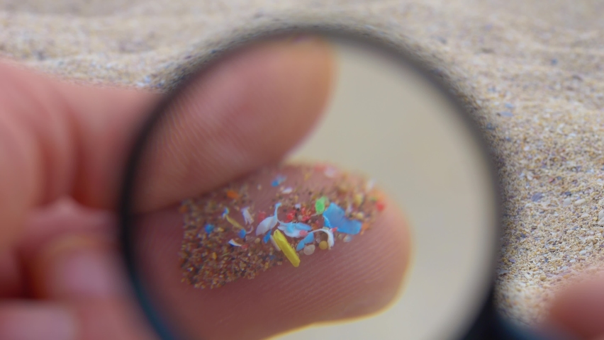 Microplastic research, colorful plastic particles in sand close up view. Taking plastic samples onshore. Plastic waste on ocean beach. Environmental pollution, ecology, disaster | Shutterstock HD Video #1096494791