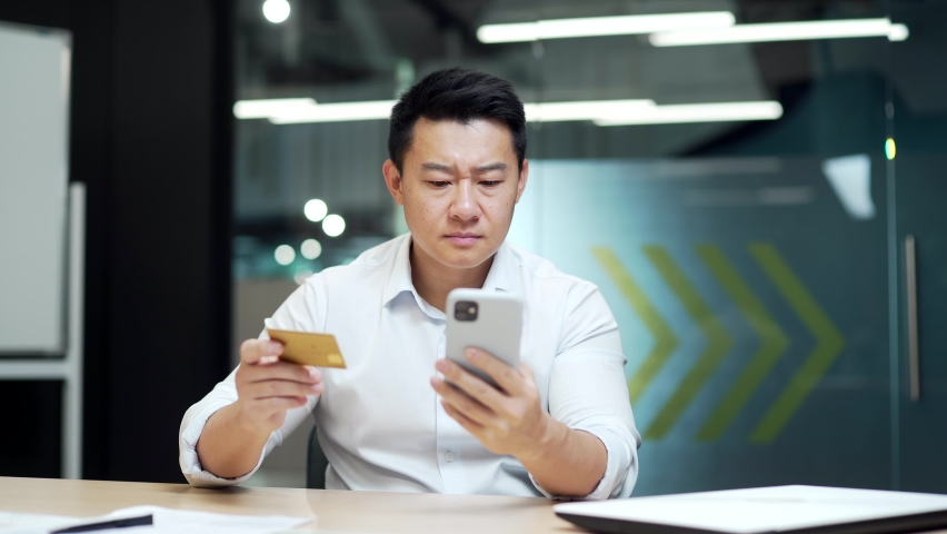 Asian Businessman making Online Payment Failure on mobile phone smartphone in Office. Male worker has difficulty problem fail With credit card. Employee could not complete transaction not enough money Royalty-Free Stock Footage #1096497251