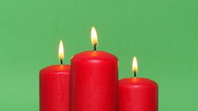 Thick red Christmas candles on a green chroma key background. The candle flame burns and dances - Powered by Shutterstock - Get 15% off with code: PIKWIZARD15