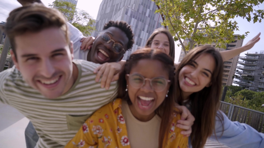 Happy Young friends looking at Camera and laughing. Smiling Group of people having fun together outdoors. Cheerful community of students university. Modern lifestyle of multicultural people joyful. Royalty-Free Stock Footage #1096499061