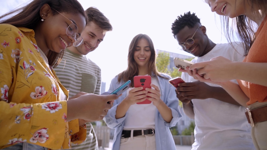 Low angle view group of young teenagers holding cell phones watching something funny on mobile screen. Surprised faces looking smartphone. Concept of technology connection community and social media  Royalty-Free Stock Footage #1096499063