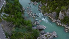 Cinematic 4k Drone Video of River between cliffs. Mountains, stones, trees, and a road next to the river. Beautiful scenery aesthetic