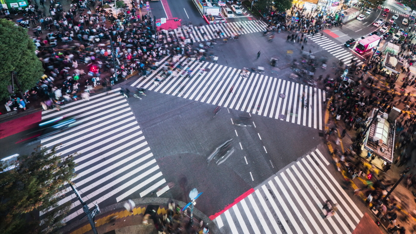 Night time lapse of car traffic transportation, crowded people walk cross road at Shibuya scramble crossing. Tokyo tourist attraction landmark, Japan tourism, Asia transport or Asian city life concept