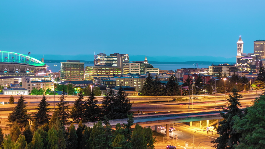 Seattle City at Night Rotating Motion Time Lapse. Ultra real 4k 60p spinning hyperlapse of downtown cityscape with headlight streaks on the freeway below skyline skyscraper buildings