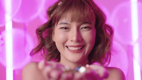 Close-up of beautiful asian woman blowing confetti at party event. Portrait of a charming beautiful girl flying sequins and confetti. Concept of the holiday, fun, celebrate. slow motion - Powered by Shutterstock - Get 15% off with code: PIKWIZARD15