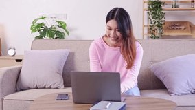 Asian female student Sit and work and study online on the sofa at home.