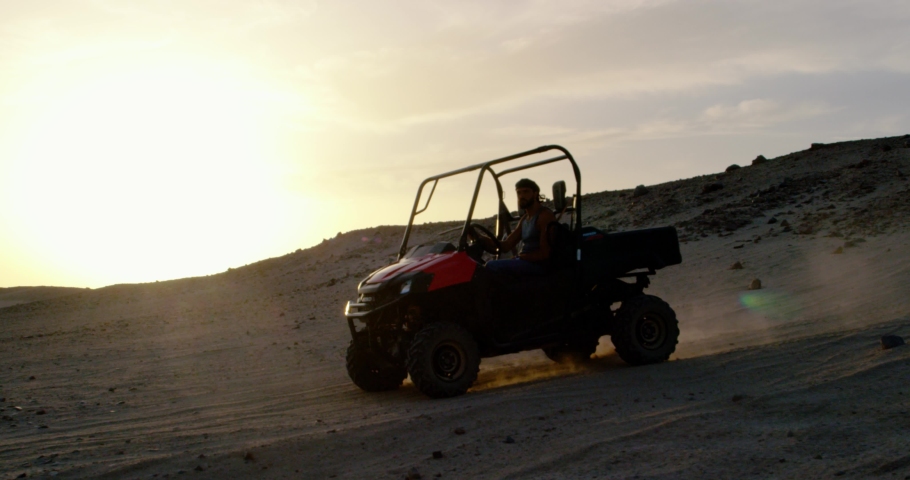 Tracking shot of buggy car moving through an african desert.
