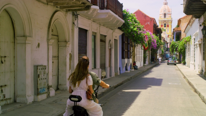 A couple on holiday in cartagena riding chopper in a narrow street. Royalty-Free Stock Footage #1096513547
