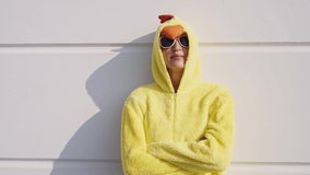 Cinematic video of a woman having fun wearing a chicken pajama costume outdoor. woman  celebrating outside. Representation of carefree concept	