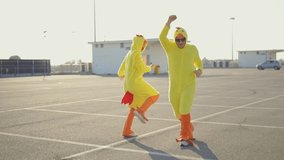 Cinematic video of a couple having fun wearing a chicken pajama costume outdoor. Man and woman celebrating outside. Representation of carefree concept	