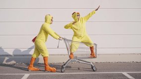 Cinematic video of a couple having fun wearing a chicken pajama costume outdoor. Man and woman celebrating outside. Representation of carefree concept	