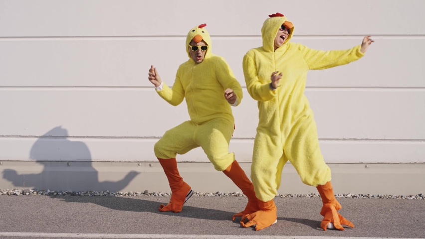 Cinematic video of a couple having fun wearing a chicken pajama costume outdoor. Man and woman celebrating outside. Representation of carefree concept	 | Shutterstock HD Video #1096519457