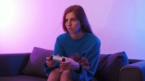 Gamer woman playing video game on TV with modern console in neon light and holding his chihuahua dog