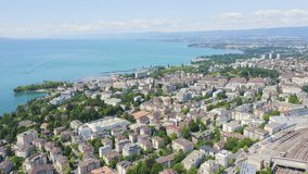 Inscription on video. Lausanne, Switzerland. Flight over the central part of the city. The coast of Lake Geneva. Blue lights form luminous. Electric style, Aerial View