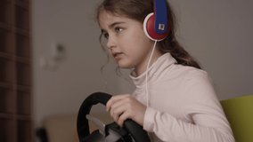 Girl Playing Racing Video Game in Game Console. Child Playing Computer Game in Headphones With Steering Wheel. Gamer With Headset Holding Steering Wheel Playing Video Game. Kid Gambling Addiction.