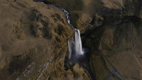 Seljalandsfoss waterfall and rural landscape, Iceland. Aerial backward tilt-up reveal