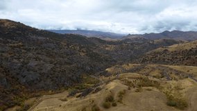 Panoramic aerial view on serpentine road through autumn mountains and hills. Cloudy foggy day drone 4K video. Wild landscape of Armenia top view. Mountains covered with vast forests.