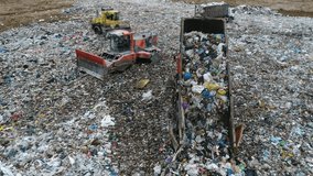 Aerial view. A dump truck unloads a pile of garbage at a landfill. Dump of unsorted waste. Drone shot of working trash management. - Powered by Shutterstock - Get 15% off with code: PIKWIZARD15
