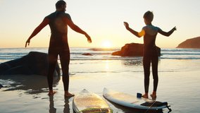 Family surf. Father and son go surfing at sunrise and do warm up exercises on the beach - Powered by Shutterstock - Get 15% off with code: PIKWIZARD15