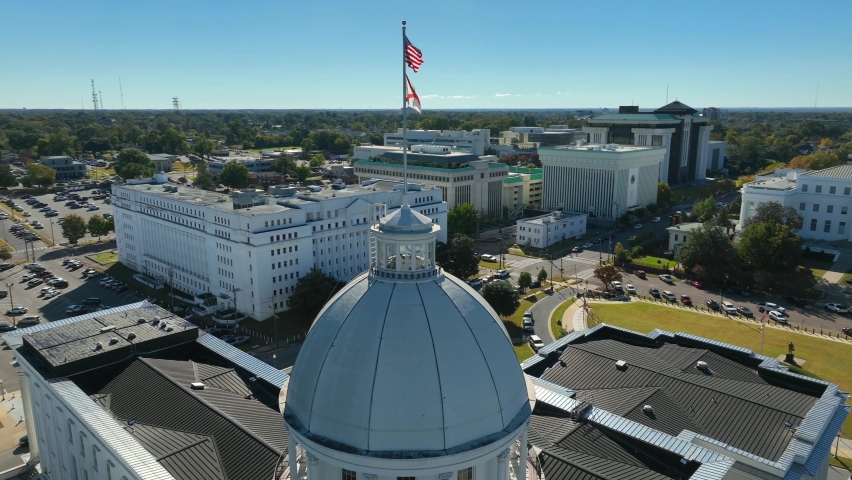 Alabama State Capitol dome in Montgomery AL. Aerial orbit of USA and Alabama flags. Historical home of Confederate States of America.