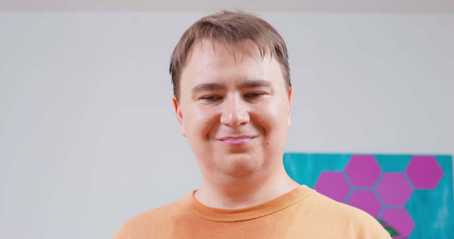 Young man looks around with a smile, when suddenly he notices something suspicious, he frowns, returns there with a glance and opens his eyes and mouth wide in shock