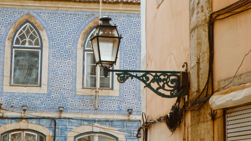 Close-up view of the typical tiled facades and a picturesque street lamp in Lisbon, two hallmarks of the Portuguese capital
 Royalty-Free Stock Footage #1096555957
