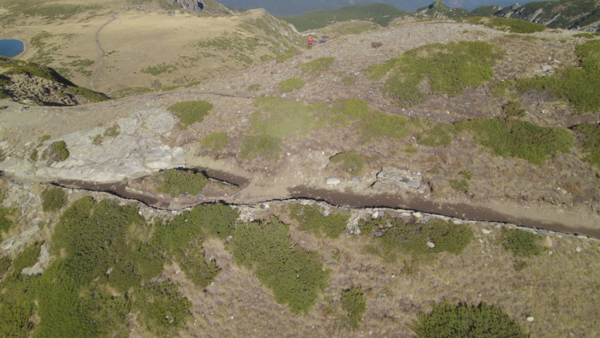 Guy stands on a cliff and admires the view of Seven Rila Lakes