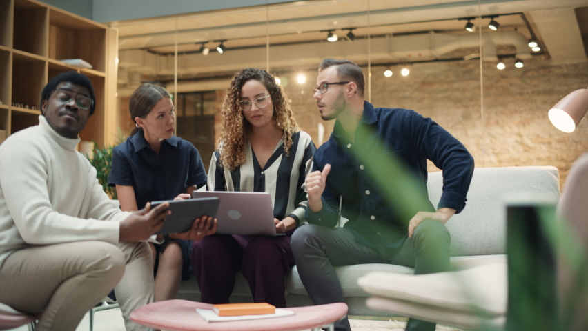 Multiethnic Group of People Brainstorming in a Meeting Room at the Office. Teammates From The Marketing Department Working on a New Campaign Using Laptop and Tablet. Handheld Slow Motion Royalty-Free Stock Footage #1096559143