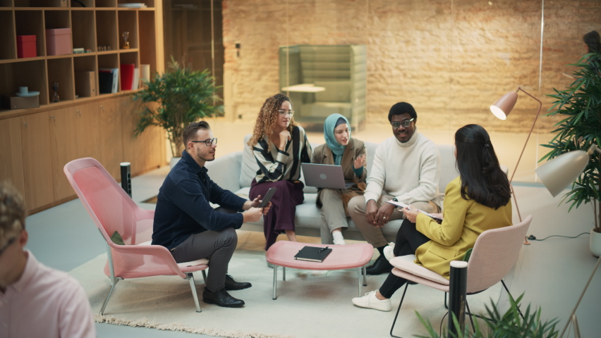 Wide Shot of a Multiethnic Group of People Discussing Ideas in a Meeting Room at Office. Businesspeople Making Creative Decisions For their Startup and Discussing Options. Descending Dolly Shot Royalty-Free Stock Footage #1096559169