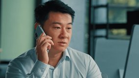 Sad Asian executive worker businessman manager middle-aged korean japanese chinese man answer mobile call work in office speak phone solve business problem distant conversation by 5g cell connection - Powered by Shutterstock - Get 15% off with code: PIKWIZARD15