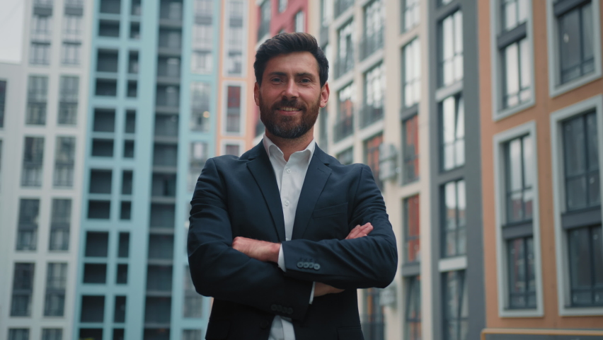 Confident boss leader successful businessman male architect standing in confident pose with crossed arms posing alone on city street outdoor modern office buildings professional career growth concept