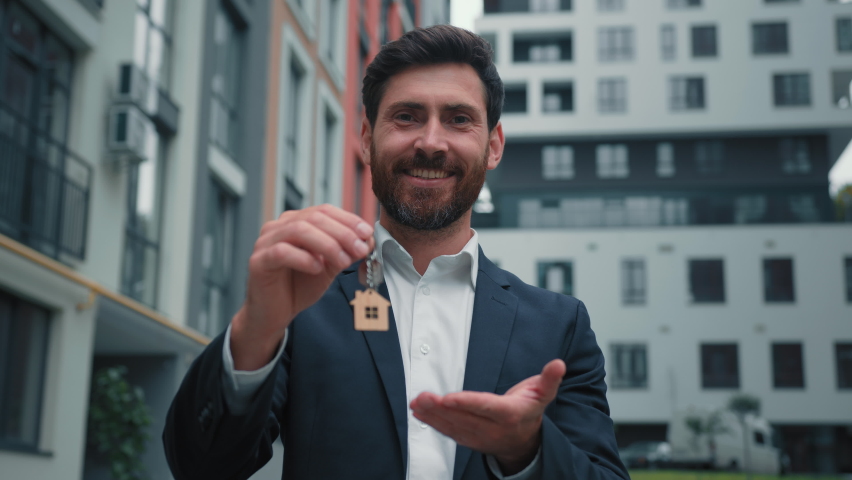 Real estate manager homeowner businessman banker salesman caucasian successful man sell house property hold keys from new apartment in city modern building construction sale commercial business deal | Shutterstock HD Video #1096561143