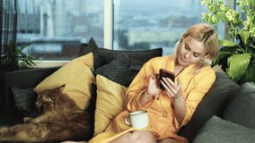 Late in the evening, a beautiful woman smiles and looks into a smartphone while sitting on a sofa in the living room. - Powered by Shutterstock - Get 15% off with code: PIKWIZARD15