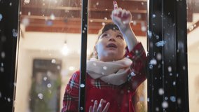 Adorable child look through the window and admiring first snow flakes. Young kid girl sitting in living room at home, watching snow falling outside enjoy celebrate Christmas, Thanksgiving with family. - Powered by Shutterstock - Get 15% off with code: PIKWIZARD15