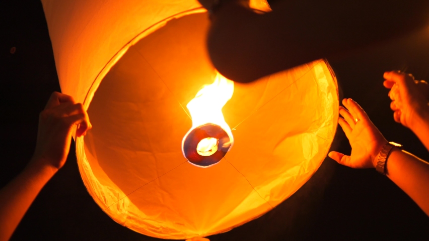 Group of People Holding and Starting Flying Burning Paper Lantern. Chiang Mai, Thailand.