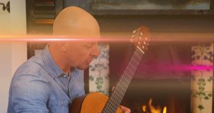 Animation of light flashing over caucasian father playing guitar and singing to son. Family, parenthood, music and spending time together concept digitally generated video.