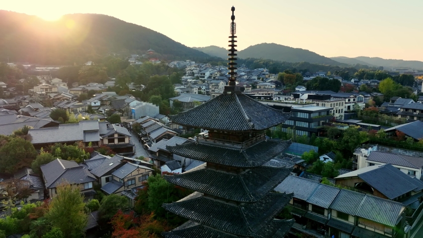 Japanese town of Kyoto at sunrise, aerial view of Yasaka pagoda, famous Japanese tourist destination in the morning, flying around historic pagoda.  Royalty-Free Stock Footage #1096589611