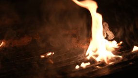 Beef steak meat on the grill. 4K close up video with a barbecue with coal fire cooking some beef steak.