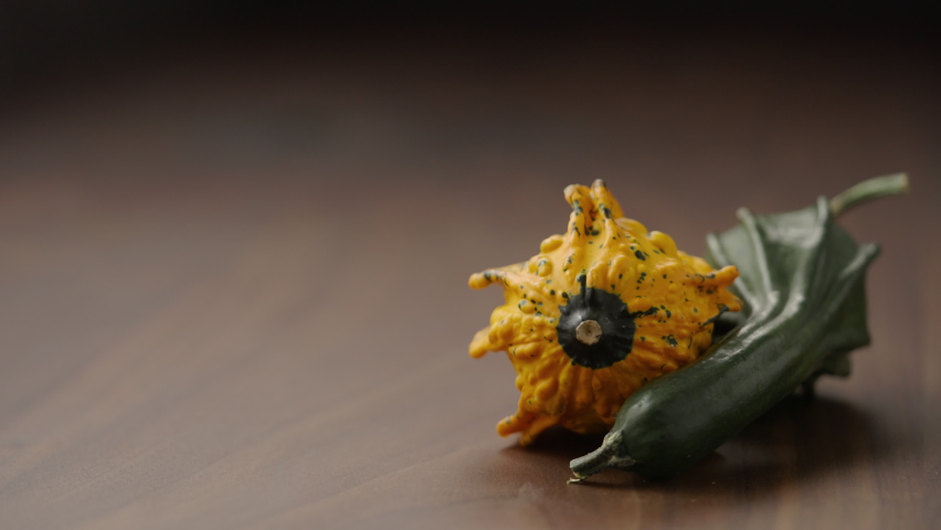 Slow motion man put thanhksgiving card next to decorative pumpkins on wood table