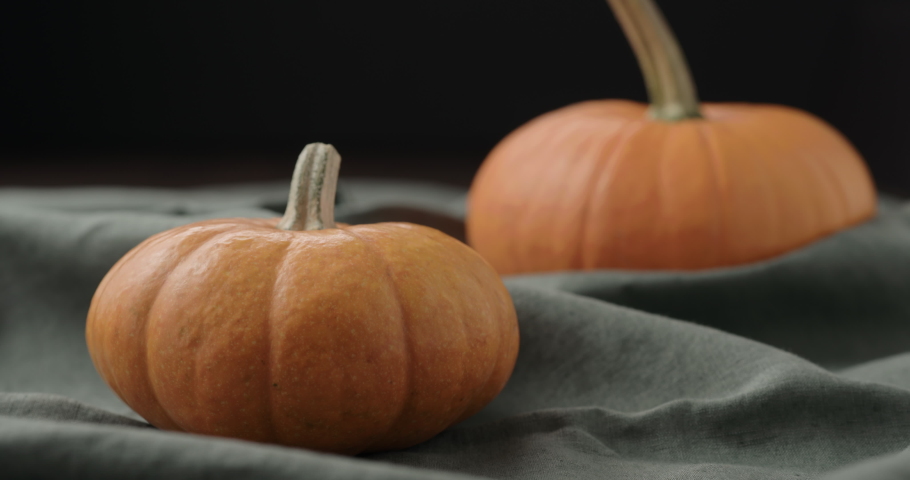 Slow motion man put thanksgiving card next to pumpkins on linen cloth