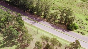 Aerial static view of a road grader widening side of the road in the countryside . High quality 4k drone footage