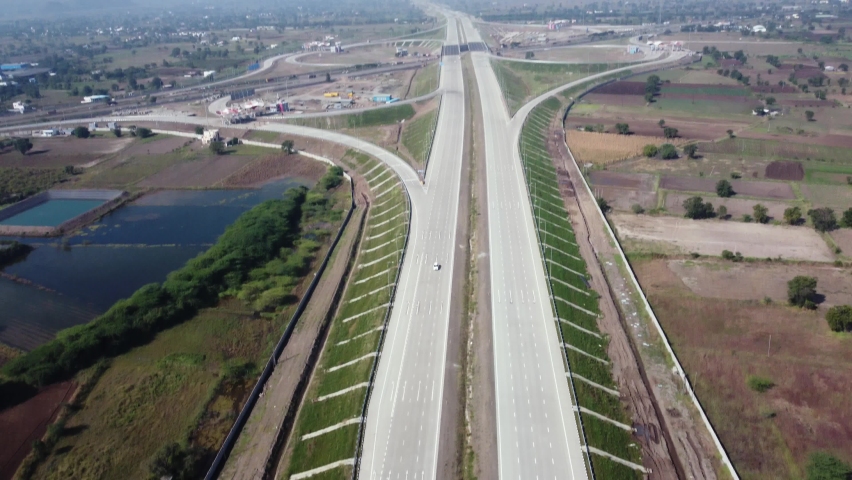 Tilting down aerial drone shot of a car on Samruddhi Mahamarg or Nagpur to Mumbai Super Communication Expressway now opened for public Royalty-Free Stock Footage #1096599851