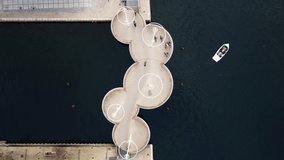 Drone top view zoom out of five circle bridge in Copenhaguen while bikes passes the bridge - boats. High quality 4k footage