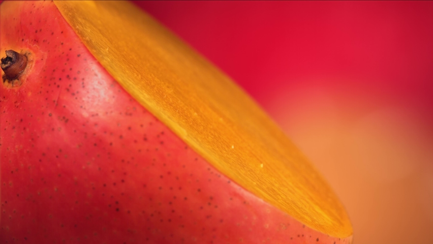 Drop of Mango Juice flows down the surface of rotating Halved King Mango. Slow Motion Royalty-Free Stock Footage #1096602875